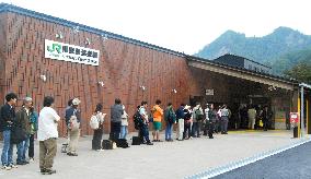 People wait to buy admission tickets for relocated station