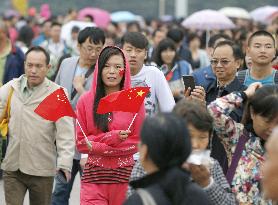 Chinese flag-waving woman walks at Tiananmen Square