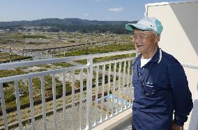 Man smiles at apartment built for 2011 disaster evacuees
