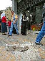 Bomb-created hole remain on shopping street in Damascus