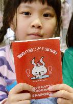 Girl holds pad for stamp collection at Japan spar resort