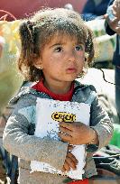 Syrian refugee girl holds biscuits in Turkey