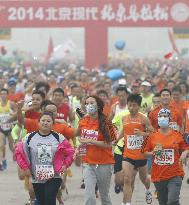 Runners wear masks to combat smog in Beijing marathon