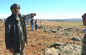 Refugee from Syria points to hometown from Turkish border