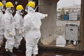 Decommissioning panel members check Fukushima plant monitor