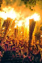 Young men hold up huge torches at Kyoto fire festival