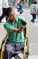 Disabled photographer pictures Bangkok on wheelchair