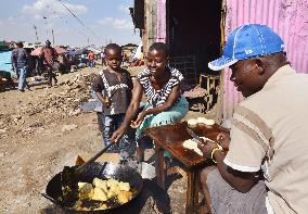 Kenyan woman cooks fried bread in slum