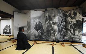 Cartoonist paints monk Shinran on folding screen
