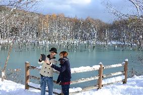 Couple checks photos of 'Blue Pond' after snowfall