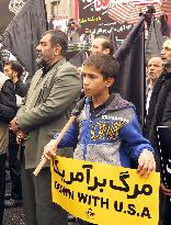Boy holds anti-U.S. placard during rally in Tehran