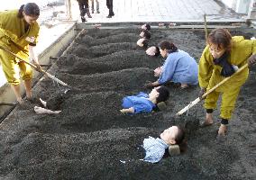 Japan, China reporters take sand baths at spa resort