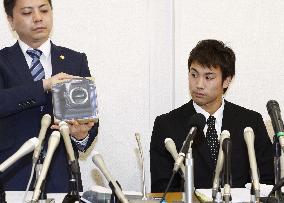 Tomita says unknown man placed camera in his bag