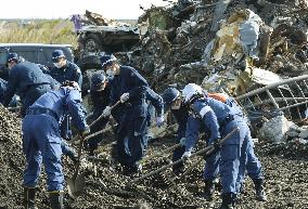 Fukushima police comb debris in coastal areas