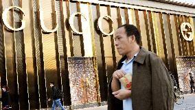 People walk by luxurious shop in Beijing