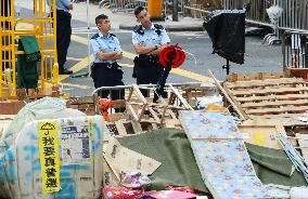 Policemen before barricades in H.K.'s occupied street