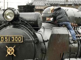 Volunteers repair weather-beaten locomotive