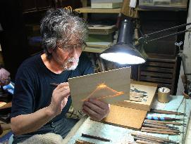 Sculptor works on bamboo openwork