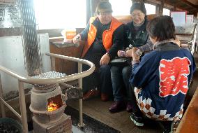 Passengers warm up on Tsugaru stove train