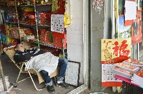 Calendar vendor in Shanghai asleep