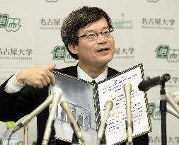 Nobel laureate Amano shows certificate upon return home