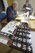 Calligraphers write names of newly elected lawmakers