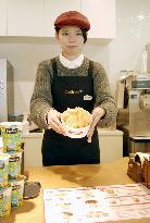 Worker at Calbee's new Kobe outlet shows potato chips