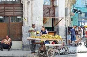 Couple sells bananas on street in Old Havana