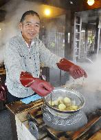 Tourist enjoys steam cooking at hot spring resort