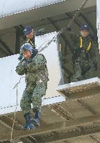 Japan's Defense Minister Nakatani inspects parachute drill