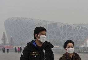 Mask-wearing citizens walk in smoggy Beijing