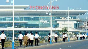Pyongyang airport officials walk toward new terminal building
