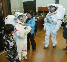 Elementary school student tries on spacesuit