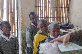 KENYA-NAIROBI-MATHARE SLUM-SCHOOL-BOOK READING