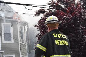 Two Houses Involved In A Multi-Alarm Large Fire In Paterson, New Jersey; Several Victims Including Firefighter Injured