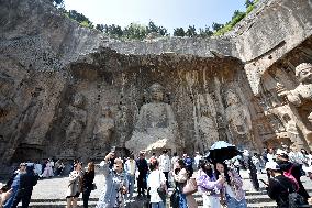 Tourists Visit The Longmen Grottoes in Luoyang