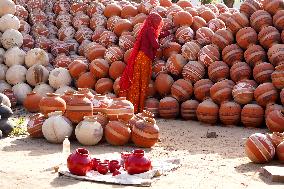 An Indian woman Arranging Pot - India