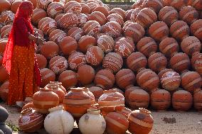 An Indian woman Arranging Pot - India