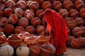 An Indian woman Arranging Pot - India