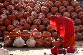 An Indian woman Arranging Pot - India