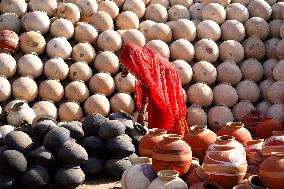 An Indian woman Arranging Pot - India