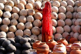 An Indian woman Arranging Pot - India