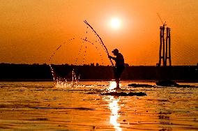 Sunset fishing on shallow Dnipro river