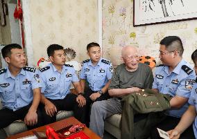 93-year-old veteran Ren Zegan presents a painting and calligraphy work to the border police in Huai 'an city, Jiangsu province,