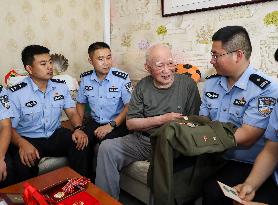 93-year-old veteran Ren Zegan presents a painting and calligraphy work to the border police in Huai 'an city, Jiangsu province,