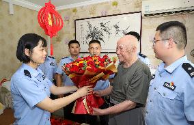 93-year-old veteran Ren Zegan presents a painting and calligraphy work to the border police in Huai 'an city, Jiangsu province,