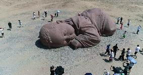 The Sculpture Son of the Earth on The Gobi Beach in Guazhou