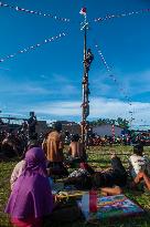 People Play The Traditional Game Of Panjat Pinang - Indonesia
