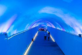Citizens and tourists play in a converted bomb shelter in Chongqing, China, August 26, 2023. The shelter is illuminated by light