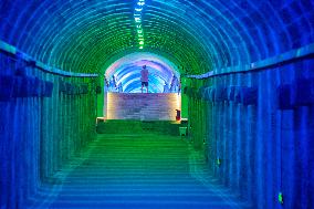 Citizens and tourists play in a converted bomb shelter in Chongqing, China, August 26, 2023. The shelter is illuminated by light